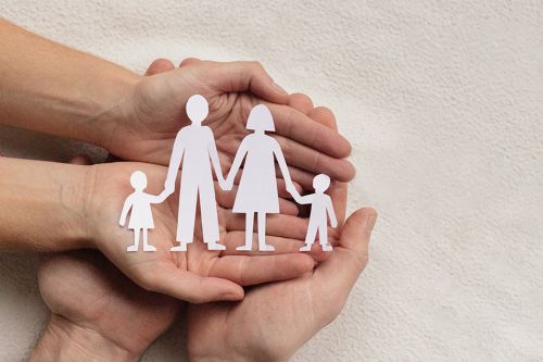 Hände mit Papierausschnitt einer Familie