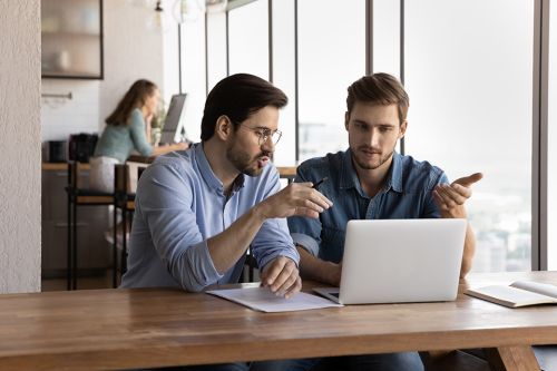 Besprechung von 2 Männern mit Laptop