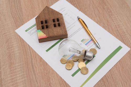 Foto: Glühbirne, Energieskala auf Haus, Münzen